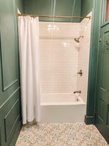 a bathroom with a tub and a shower curtain at Historic Knox Hotel in Princeton