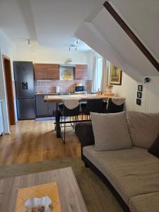 a living room with a couch and a kitchen at Apartman Gorski raj in Fužine