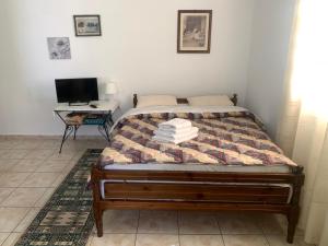 a bedroom with a bed with a television and a desk at Το σπίτι της Ελένης in Vlakhiá