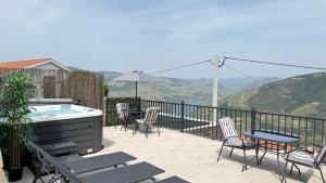 a patio with a hot tub and chairs and a table at River Breeze Douro - Casa Touriga in Marmelal