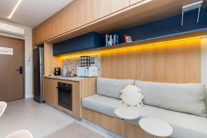 a living room with a couch and a kitchen at GRU Residence by Housi in Guarulhos
