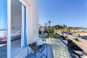 a balcony with a table and chairs and a view of a street at Sea View Hotel Fronte Mare in San Vito lo Capo