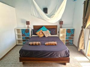 a bedroom with a bed with purple sheets and pillows at Beach House in Saly Portudal
