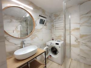 a bathroom with a sink and a washing machine at Villa MegaLit - відпочинок у котеджах з чанами біля Косино та Берегово in Velyka Bihanʼ