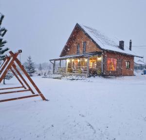 a house with a sign in front of it in the snow at Konoba Taline Sokolac in Rešetnica