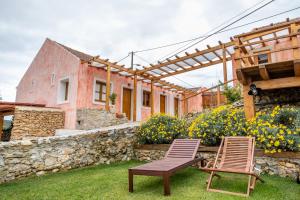 two chairs and a table in the yard of a house at Terra Lodge in Ericeira