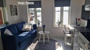 a living room with a blue couch and a kitchen at Ellas Brygga in Karlskrona +10 photos