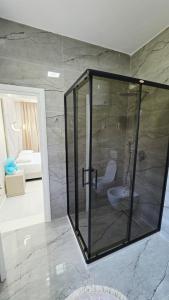 a bathroom with a glass shower with a toilet at Selimi House in Shirokë +25 photos