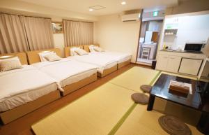Cette chambre comprend 2 lits et une table. dans l'établissement Sarangbang, à Kyoto