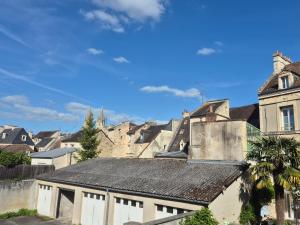 a group of buildings in a city with a palm tree at Maison au calme 2 chambres centre de Caen in Caen