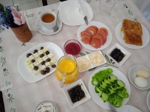 a table with plates of breakfast foods and a cup of coffee at Velia Rooms in Përmet