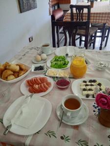 a table with plates of food and a cup of tea at Velia Rooms in Përmet +18 photos