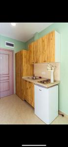 a kitchen with a white refrigerator and a pink door at Hotel Solaris in Čanj