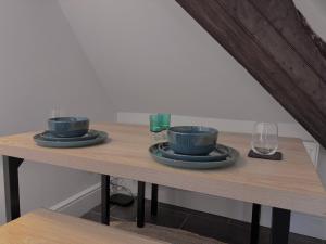 a wooden table with two bowls and glasses on it at The Eaves - Pen Y Fan Views in Brecon +10 photos
