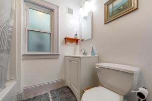 a bathroom with a toilet and a sink and a window at Walkable 3-Unit Hub: 8 Mi to Micron Technology! in Phoenix +37 photos