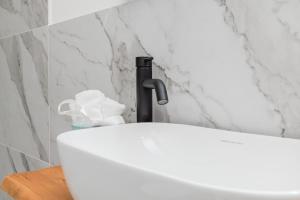 a white sink with a faucet in a bathroom at Charming Open Space in Costa Smeralda in Olbia +8 photos