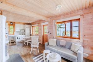 a living room with a couch and a kitchen at Tyyni Resort - Hirsihuvila Aalto in Liperi