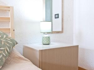 a lamp on a night stand next to a bed at Charming Open Space in Costa Smeralda in Olbia