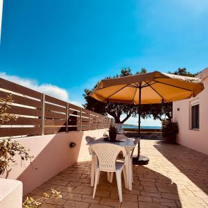 a table and chairs under an umbrella on a patio at Baloma Apartment in Falasarna