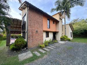 a brick house with a palm tree in front of it at Finca Panaca Jaguey 7 in Quimbaya