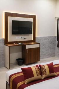 a room with a tv and a bed with a couch at Hotel Urban Inn - The RK Hospitality Group #Prem Mandir #Chaar Dham Fully AC in Vrindāvan