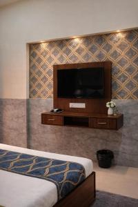 a bedroom with a flat screen tv on a wall at Hotel Urban Inn - The RK Hospitality Group #Prem Mandir #Chaar Dham Fully AC in Vrindāvan +12 photos
