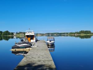 three boats docked at a dock on a lake at Ellas Brygga in Karlskrona