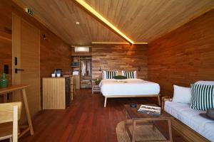 a bedroom with a bed and a couch in a room at Mili Resort in Polychrono