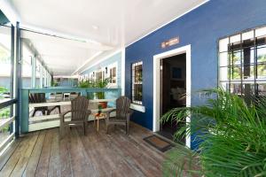 a porch with a table and chairs and a blue wall at Blue Horizon Studios in Roatán