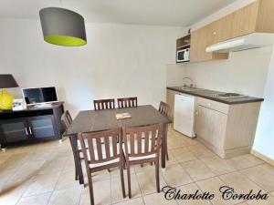 a kitchen with a table and chairs in a room at Appartement T3 Golf Albret in Barbaste +7 photos