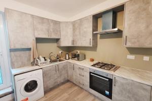 a kitchen with a washing machine and a washer at Jurassic Coast Gateway Exmouth Escape in Exmouth +11 photos