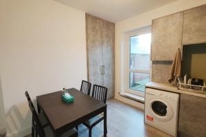 a kitchen with a table and a washing machine at Jurassic Coast Gateway Exmouth Escape in Exmouth