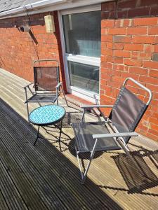 two chairs and a table on a porch at Jurassic Coast Gateway Exmouth Escape in Exmouth