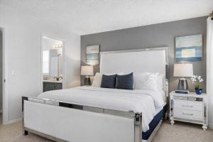 a bedroom with a large white bed with two lamps at Amazing Star Wars Villa - Theater, Full Arcade & Private Pool, 5BR Near Disney in Orlando