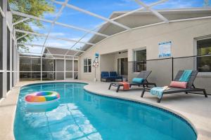 a swimming pool with two lounge chairs and a swimming poolvisor at Amazing Star Wars Villa - Theater, Full Arcade & Private Pool, 5BR Near Disney in Orlando