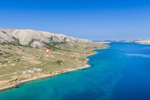 an island with a red marker in the water at Villa Serenity Pag Sv. Marko in Pag