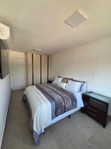 a bedroom with a large bed and a desk at Apartamento espaçoso de luxo in Goiânia