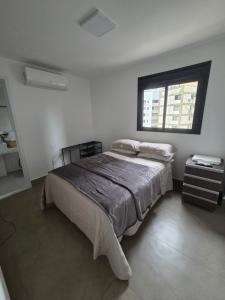 a bedroom with a bed and a window at Apartamento espaçoso de luxo in Goiânia