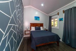 a bedroom with a bed with a blue bedspread at Blue Horizon Studios in Roatán