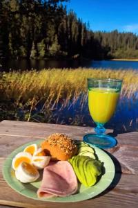 a plate of food and a glass of orange juice at Cozy lakeside cabin in Buvika +11 photos