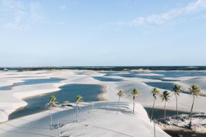 an aerial view of a beach with palm trees and water at Kite Mansion Arpoador in Tutóia