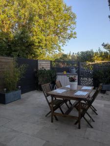 a wooden table and two chairs on a patio at Maison moderne et lumineuse in Cavaillon