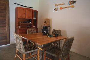 a wooden table with chairs and a laptop on it at Kite Mansion Arpoador in Tutóia +22 photos