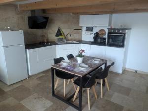 a kitchen with a table with chairs and a refrigerator at Maison moderne et lumineuse in Cavaillon