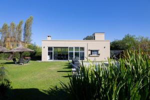 a white house with a yard with grass at Vi Hosting Cabañas in Salta