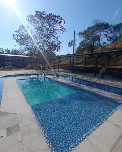 a pool with a sprinkler spraying water over it at Hotel Estação Chico in Garanhuns