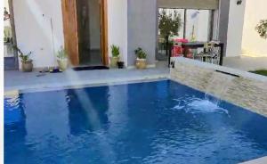 a swimming pool with blue water in a house at Tawfik in Midoun