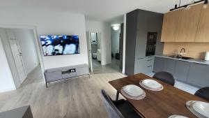a living room with a dining table and a flat screen tv at Apartament Mickiewicza in Staszów