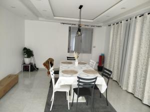 a white dining room with a white table and chairs at Tawfik in Midoun