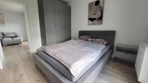 a bedroom with a bed and a chair at Apartament Mickiewicza in Staszów